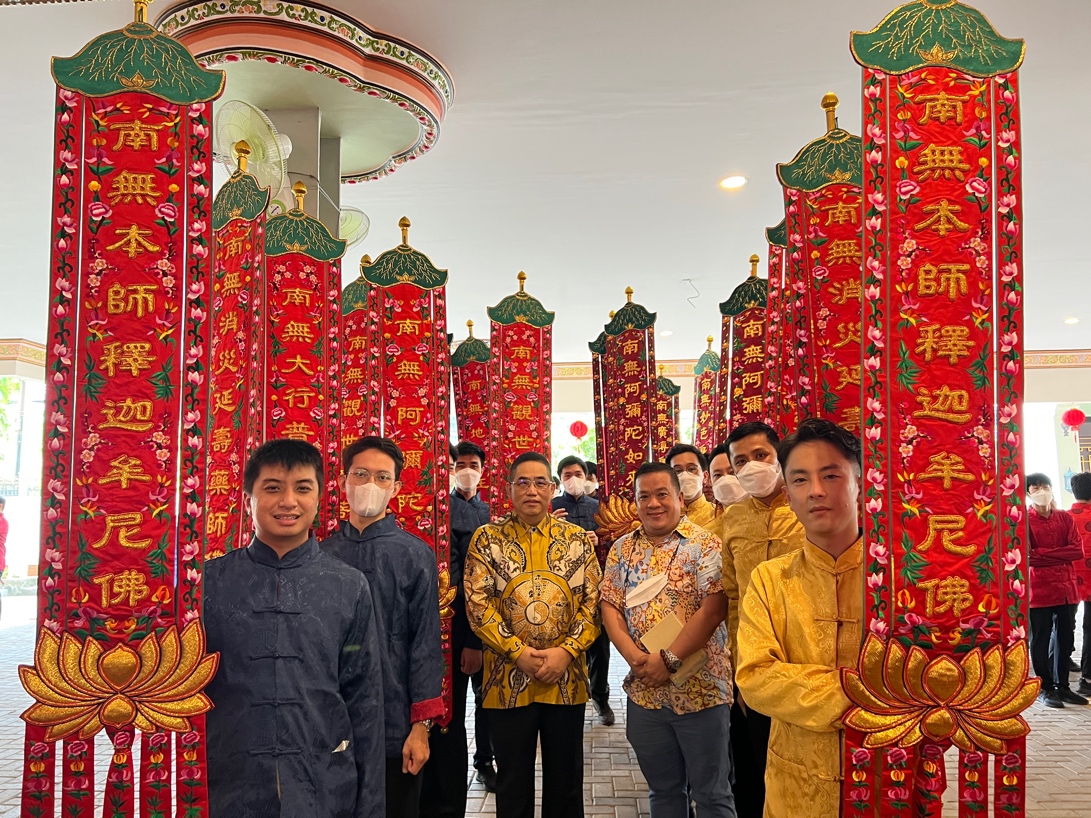 A group of people posing for a photo in front of a colorful temple

Description automatically generated with medium confidence