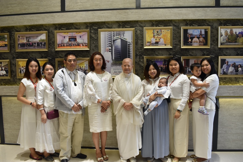 A group of people in white lab coats standing in front of a wall of pictures

Description automatically generated with low confidence