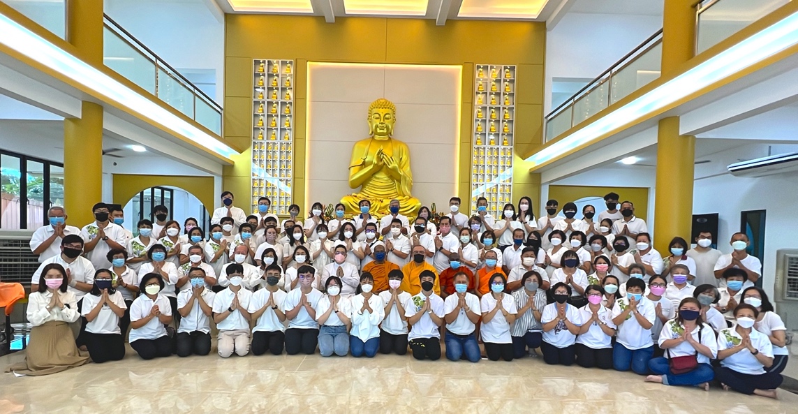 A group of people posing for a photo in front of a statue

Description automatically generated